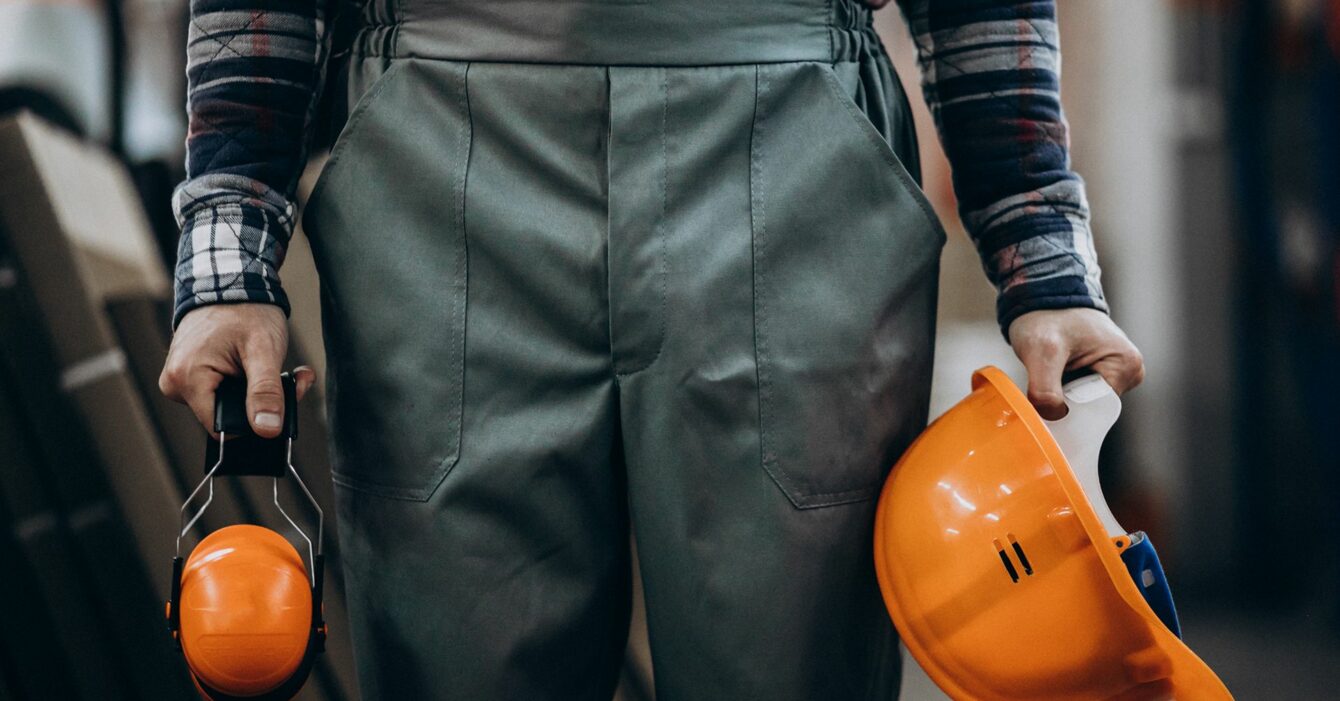 young-male-handyman-with-safety-earphones young-male-handyman-with-safety-earphones